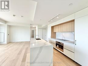 Toronto (Annex) condo for rent - A modern kitchen with white cabinets and a wooden island.