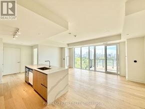 Toronto (Annex) condo for rent - A spacious kitchen with wooden floors and a large window overlooking the city.