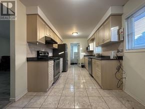 Markham (Thornhill) apartment for rent - A kitchen with tile flooring and beige cabinets.