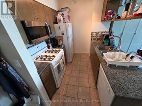 Toronto (Waterfront Communities) condo for rent - A kitchen with a stove top oven, refrigerator, microwave, and sink.