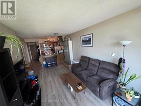 Toronto (Waterfront Communities) condo for rent - A living room with a grey couch and a wooden coffee table.