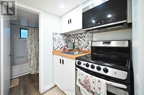 Toronto (Woodbine-Lumsden) apartment for rent - A small kitchen with a stove top oven and a microwave.