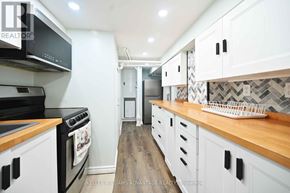 Toronto (Woodbine-Lumsden) apartment for rent - A modern kitchen with white cabinets and a wooden countertop.