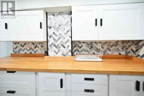 Toronto (Woodbine-Lumsden) apartment for rent - A kitchen with white cabinets and a wooden counter top.