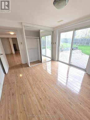 Toronto (L'amoreaux) apartment for rent - A room with wooden flooring and sliding glass doors leading to a backyard.