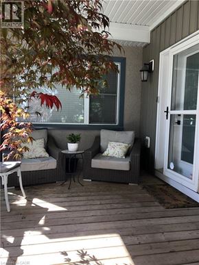 Niagara-On-The-Lake apartment for rent - A patio with a couch, chair, and potted plant.