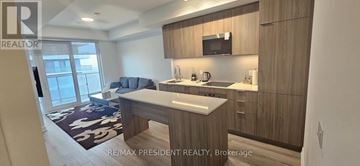 Brampton (Bram East) condo for rent - A modern kitchen with wooden cabinets and a large island.