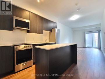 Toronto (Briar Hill-Belgravia) condo for rent - A kitchen with dark wood cabinets and stainless steel appliances.