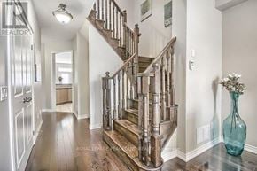 Oakville (Go Glenorchy) townhouse for rent - A wooden staircase with a glass balustrade leads up to a landing.