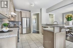 Oakville (Go Glenorchy) townhouse for rent - A kitchen with a refrigerator, sink, and countertop.