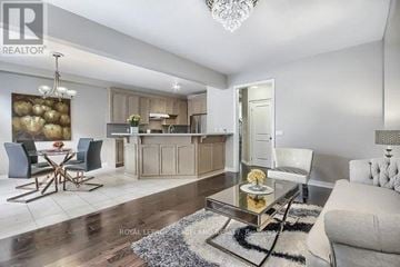 Oakville (Go Glenorchy) townhouse for rent - A modern living room with a glass coffee table and a dining table with chairs.