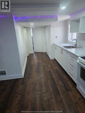 Windsor apartment for rent - A kitchen with white cabinets and a wooden floor.