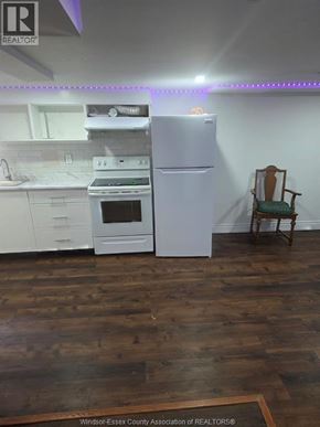 Windsor apartment for rent - A kitchen with a white fridge and a chair.