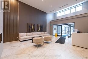 Milton (Walker) condo for rent - A reception area with a white sofa and a white chair.