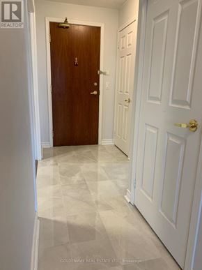 Toronto (Bayview Village) condo for rent - A hallway with a wooden door and white walls.