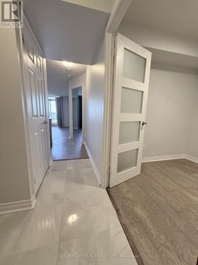 Toronto (Bayview Village) condo for rent - A hallway with white doors and a tiled floor.
