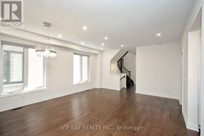 East Gwillimbury (Holland Landing) apartment for rent - A spacious room with wood flooring and a chandelier.