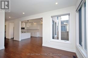East Gwillimbury (Holland Landing) apartment for rent - A spacious living room with wood flooring and a kitchen area in the background.