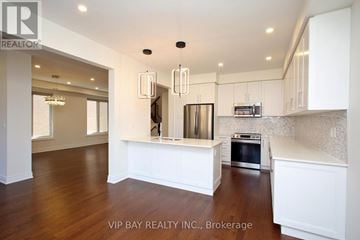 East Gwillimbury (Holland Landing) apartment for rent - A kitchen with white cabinets and a stainless steel refrigerator.