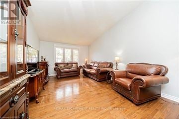 Brantford apartment for rent - A living room with brown leather furniture and wooden floors.