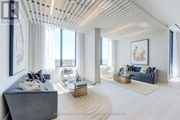 Toronto (Humewood-Cedarvale) condo for rent - A spacious living room with a grey sofa and a wooden ceiling.