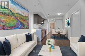 Burlington (Alton) condo for rent - A living room with a white couch and a painting on the wall.