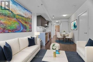 Burlington (Alton) condo for rent - A living room with a white couch and a painting on the wall.