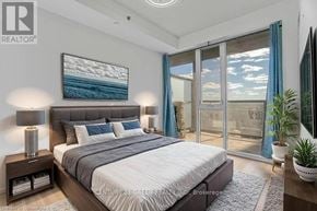 Burlington (Alton) condo for rent - A bedroom with a large bed and a painting of a beach scene on the wall.