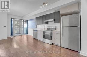 Burlington (Alton) condo for rent - A modern kitchen with stainless steel appliances and wooden flooring.
