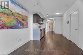 Burlington (Alton) condo for rent - A long hallway with a painting on the wall and a white cabinet.