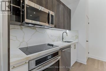 Toronto (Waterfront Communities) condo for rent - A modern kitchen with a stainless steel oven and microwave.
