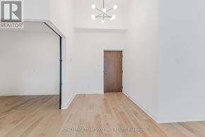 Toronto (Waterfront Communities) condo for rent - A room with a wooden floor and a brown door.