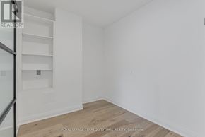 Toronto (Waterfront Communities) condo for rent - A white room with a wooden floor and a staircase.