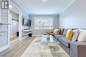 Toronto (O'connor-Parkview) apartment for rent - A living room with a grey couch, a glass coffee table, and a flat screen TV mounted on the wall.
