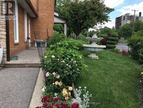Toronto (Willowridge-Martingrove-Richview) apartment for rent - A garden with a fountain and flowers in front of a house.