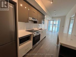 Toronto (Don Valley Village) condo for rent - A modern kitchen with a refrigerator, stove, and oven.