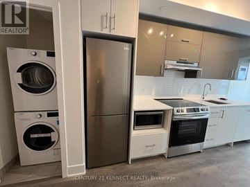 Toronto (Don Valley Village) condo for rent - A modern kitchen with a stainless steel refrigerator and white appliances.