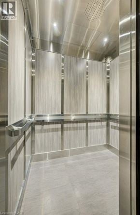 London apartment for rent - A modern, empty elevator with metallic walls and floors.