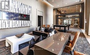 Oakville (Wm Westmount) condo for rent - A modern living room with a large flat screen TV mounted on the wall.