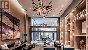 Oakville (Wm Westmount) condo for rent - A modern living room with a large chandelier and a painting on the wall.
