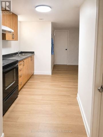 Welland (N. Welland) apartment for rent - A kitchen with wooden floors and black appliances.