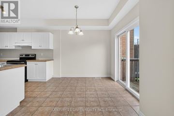 Hamilton (Stoney Creek) townhouse for rent - A kitchen with white cabinets and a tiled floor.
