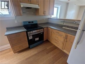 Hamilton apartment for rent - A kitchen with wooden cabinets and a black stove top oven.
