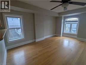 Hamilton apartment for rent - A room with a ceiling fan and two windows.