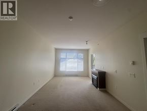 Pitt Meadows apartment for rent - A large empty room with a window and a cabinet.
