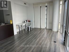 Toronto (Bay Street Corridor) condo for rent - A room with a wooden floor and a white table with chairs.