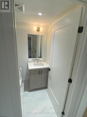 Toronto (Englemount-Lawrence) condo for rent - A white bathroom with a sink, mirror, and toilet.