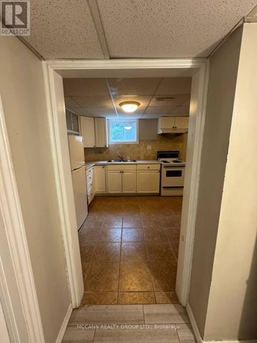 Toronto (Brookhaven-Amesbury) apartment for rent - A kitchen with white cabinets and a tile floor.