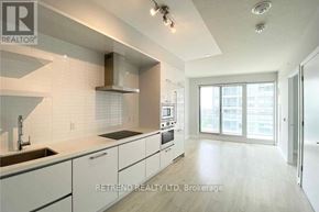 Toronto (Mount Pleasant West) condo for rent - A modern kitchen with white cabinets and a large window.