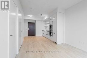 Toronto (Mount Pleasant West) condo for rent - A spacious, empty room with a door on the left and a kitchen area on the right.